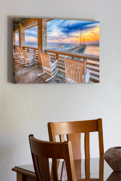 20"x30" x1.5" stretched canvas print hanging in the dining room of A line of rocking chairs looking out over Jennette's Pier in Nags Head, NC.