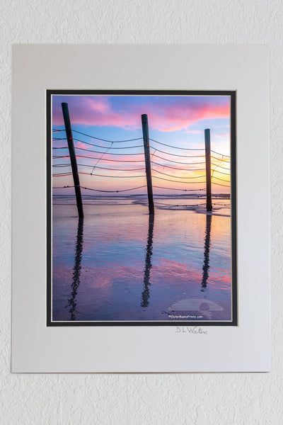 8 x 10 luster print in a 11 x 14 ivory and black double mat of Fence reflection at sunrise that keeps the wild horses north of Corolla on the Outer Banks of North Carolina.