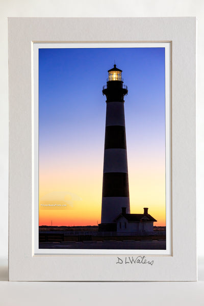 4 x 6 luster print in a 5 x 7 ivory mat of The first rays of warm orange light to peek over the horizon at Bodie Island Lighthouse.