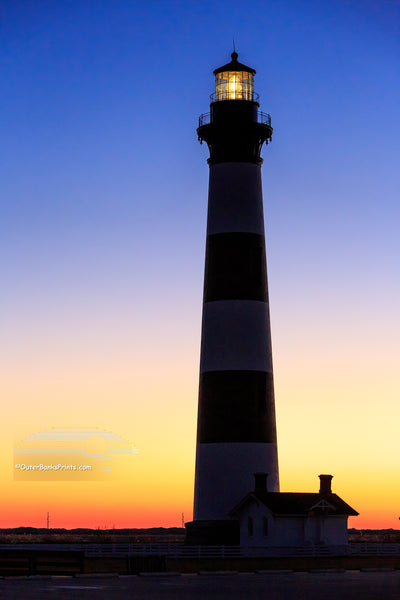 The first rays of warm orange light to peek over the horizon at Bodie Island Lighthouse.