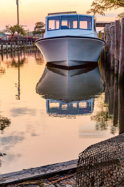 Fishing boat tied up next to  the dock at sunrise on the Outer Banks of NC.