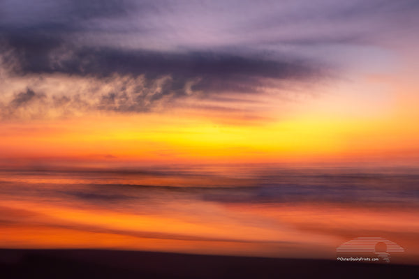 This sunrise beach impression was captured bouncing along wile driving on the beach using a 1/4 second shutter speed. in Corolla on the Outer Banks of North Carolina.