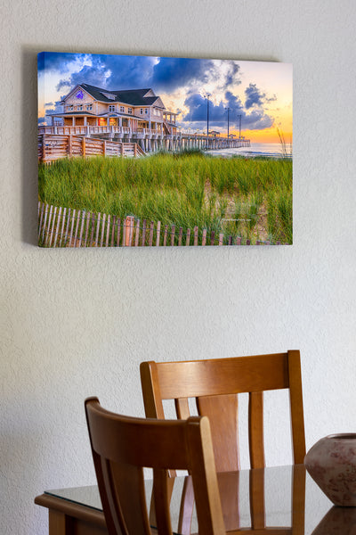 20"x30" x1.5" stretched canvas print hanging in the dining room of Sand fence, sea oats, and sunrise at Jennette's Pier Nags Head, North Carolina.