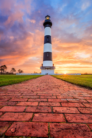 A brick path leading to Bodie Island Lighthouse at sunrise on the Outer Banks of North Carolina.