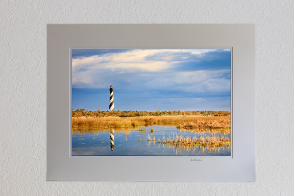13 x 19 luster print in 18 x 24 ivory ￼￼mat of Cape Hatteras lighthouse reflected in the wild marshy landscape on the Outer Banks of NC.