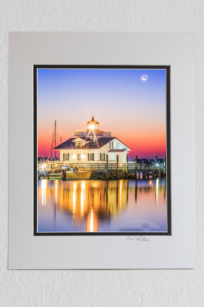 8 x 10 luster print in a 11 x 14 ivory and black double mat of Roanoke Marshes Lighthouse in Manteo North Carolina with the moon setting behind it.   The sun is just brightening the sky and reflecting in the calm waters of Shallowbag Bay.
