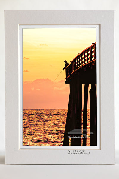4 x 6 luster print in a 5 x 7 ivory mat of Picture of a fishermen silhouetted at the end of Kitty Hawk Pier.