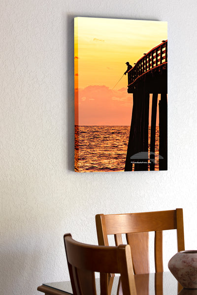 20"x30" x1.5" stretched canvas print hanging in the dining room of Picture of a fishermen silhouetted at the end of Kitty Hawk Pier.