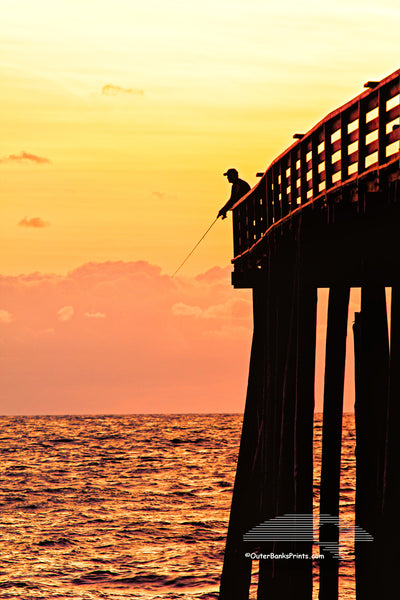 Picture of a fishermen silhouetted at the end of Kitty Hawk Pier.