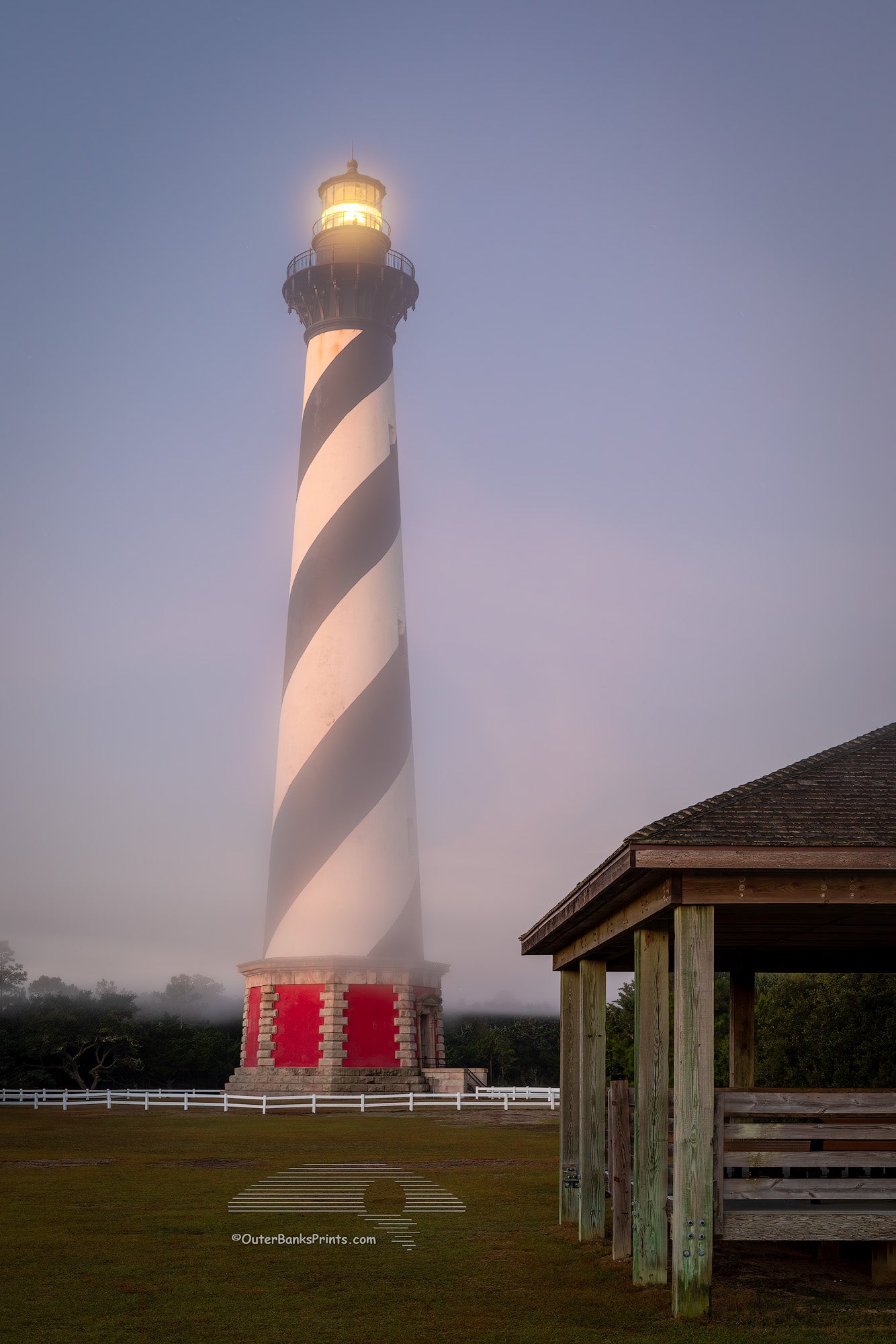 Early morning photo of Cape Hatteras lighthouse with fog forming around the base at Cape Hatteras National Seashote in Buxton, NC.