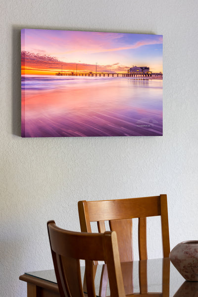 20"x30" x1.5" stretched canvas print hanging in the dining room of Sunrise colors reflect off shallow waves as they slide back into the sea at Jennette's Pier.