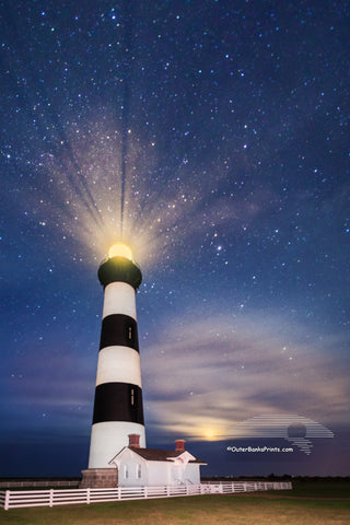 Bodie Island Lighthouse at night with stars and moon on the Outer Banks of NC.