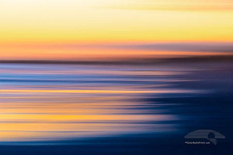 Intentional camera movement to create long streaks of light at sunset along Frisco beach in Cape Hatteras National Seashore, NC.