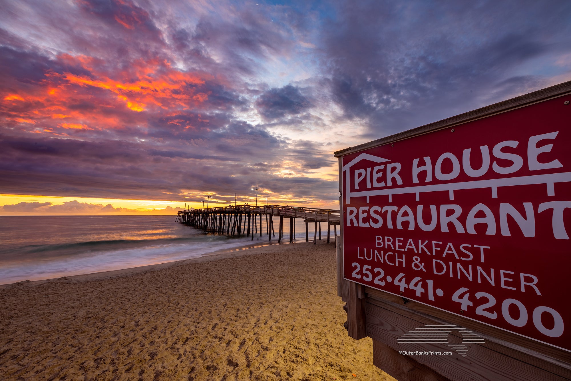 Sunrise photo of the Pier House Restaurant sign at Nags Head Fishing Pier in Nags Head on the Outer Banks of NC.