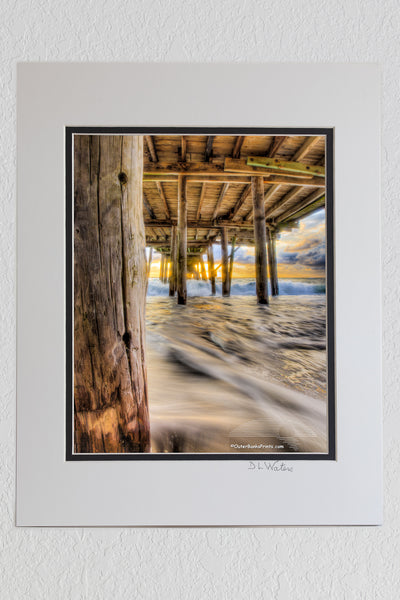 8 x 10 luster print in a 11 x 14 ivory and black double mat of Moving waves at sunrise under Avalon Fishing Pier, Kill Devil Hills along the NC coast.