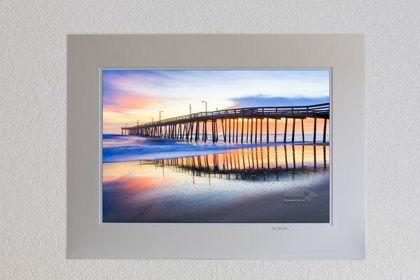 13 x 19 luster print in 18 x 24 ivory ￼￼mat of Nags Head Fishing Pier at sunrise reflected in the wet sand beach on the Outer Banks of NC.