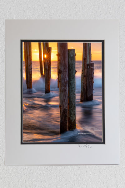 8 x 10 luster print in a 11 x 14 ivory and black double mat of Long exposure of the surf and a sun star under Avalon Fishing Pier in Kill Devil Hills on the Outer Banks.