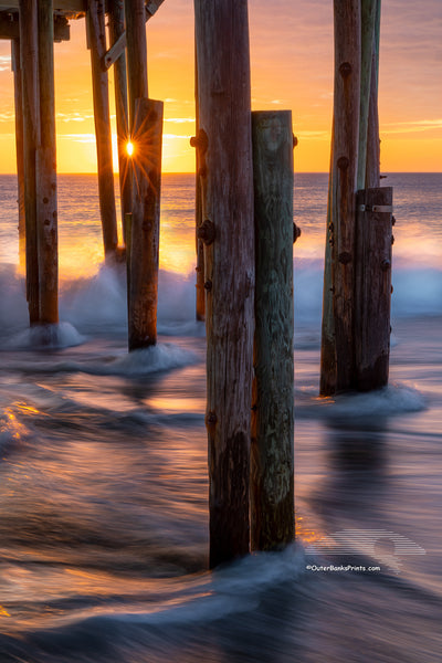 Long exposure of the surf and a sun star under Avalon Fishing Pier in Kill Devil Hills on the Outer Banks.