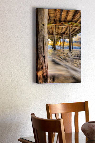 20"x30" x1.5" stretched canvas print hanging in the dining room of Moving waves at sunrise under Avalon Fishing Pier, Kill Devil Hills along the NC coast.