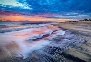 Colorful sunrise over surf at Coquina Beach in Cape Hatteras National Seashore on the Outer Banks of NC.