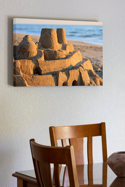 20"x30" x1.5" stretched canvas print hanging in the dining room of Elaborate sand castle at sunrise on a Outer Banks beach.