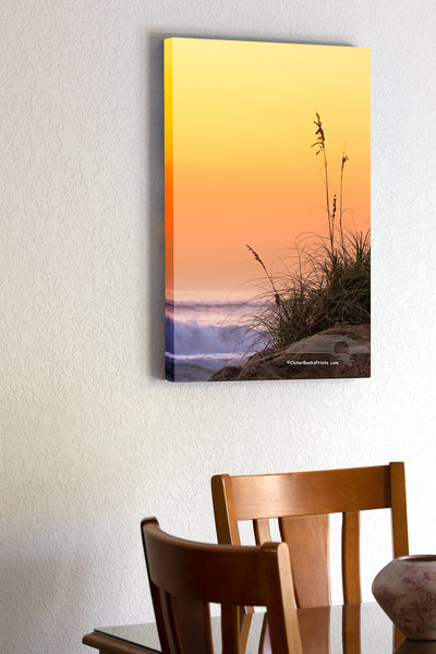 20"x30" x1.5" stretched canvas print hanging in the dining room of Silhouette of sea oats and sand dunes against a peach colored sky and surf on a Outer Banks beach.