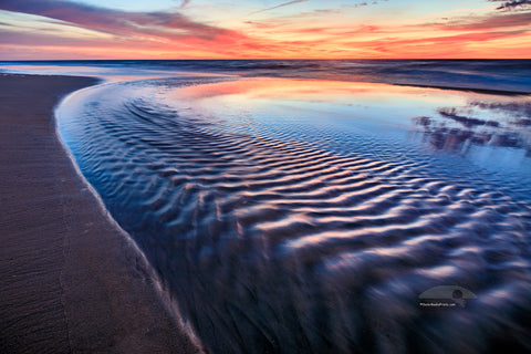 Sea water from a tie pool flowing back into the ocean just before sunrise at a Corolla beach on the Outer Banks of NC.