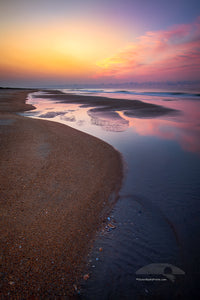 Empty beach with tide pools at sunrise on Frisco Beach. Cape Hatteras Outer Banks of North Carolina.