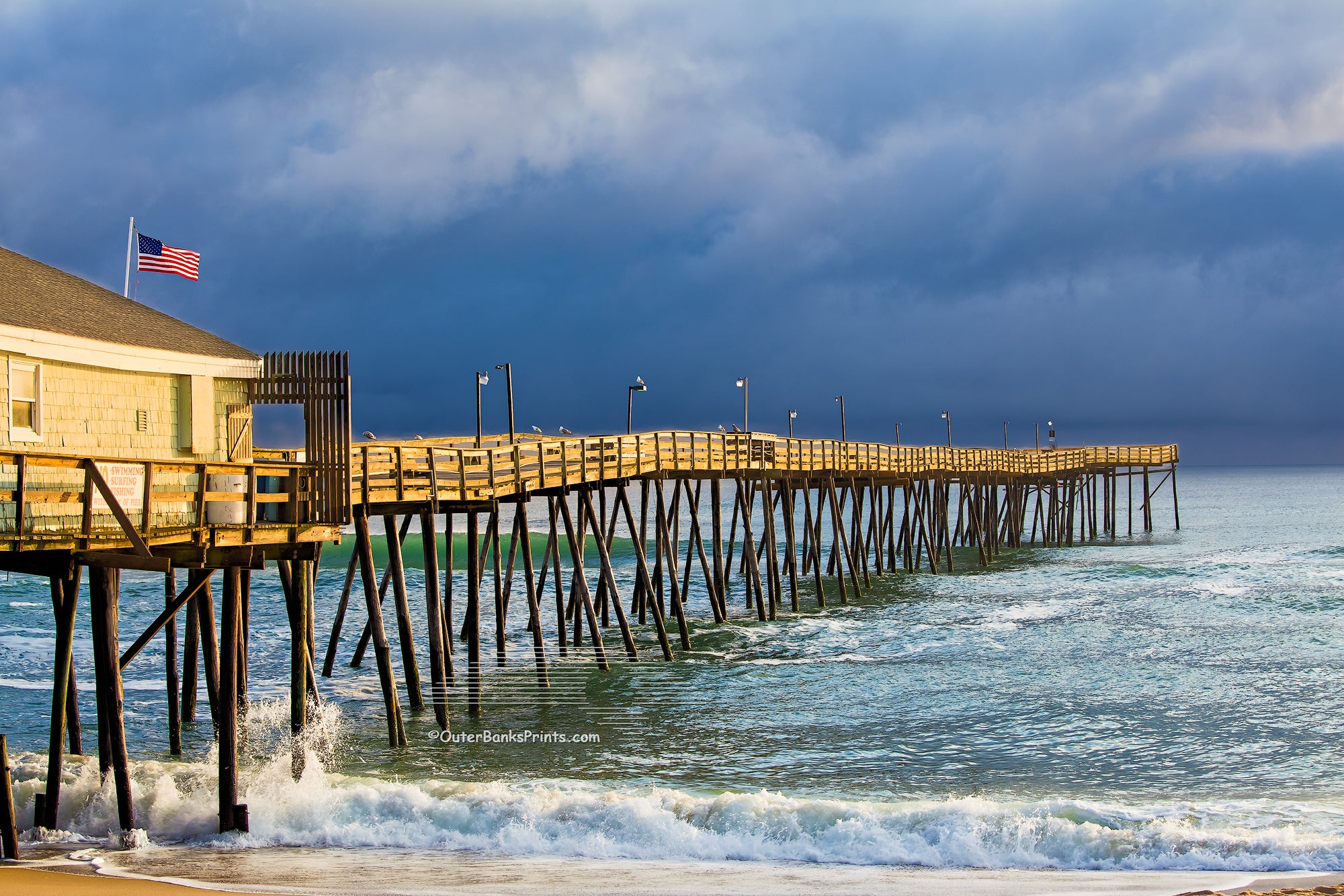 Sunshine on Avalon Fishing Pier on a stormy afternoon at the Outer Banks of North Carolina. 