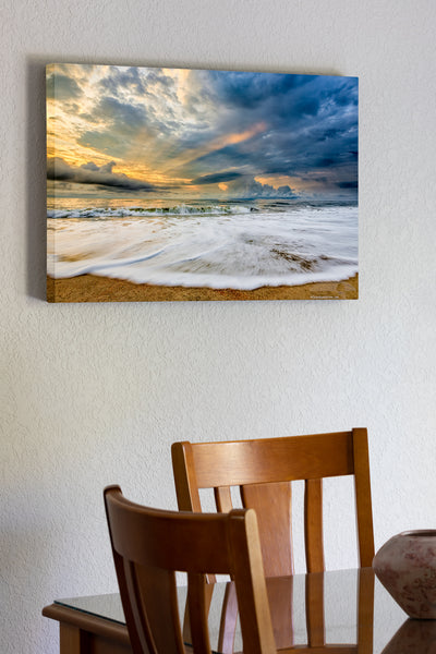 20"x30" x1.5" stretched canvas print hanging in the dining room of Sunrise and clouds with light rays poking through stormy skies over Kill Devil Hills beach on the Outer Banks of NC.