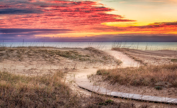 Clouds at sunris with a curvy path leading to a Kitty Hawk Beach on the Outer Banks of NC.