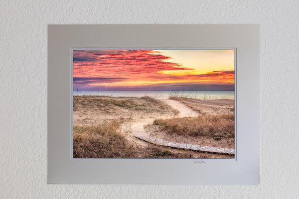 13 x 19 luster print in 18 x 24 ivory ￼￼mat of Clouds at sunris with a curvy path leading to a Kitty Hawk Beach on the Outer Banks of NC.