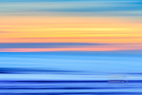 A Outer Banks beach sunrise reduced to colors and lines. Using camera movement during a long exposure to blur the beach and ocean.