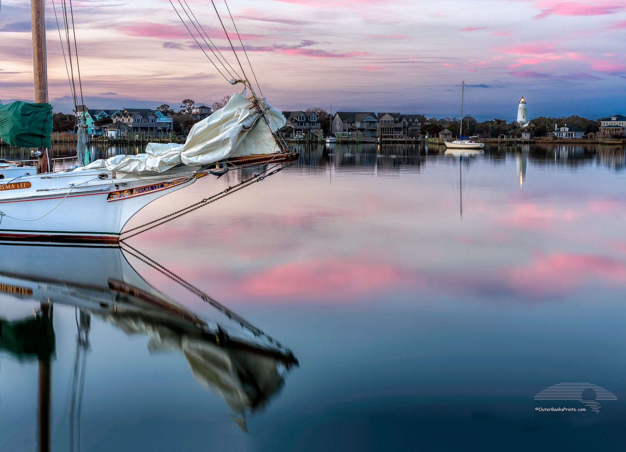 Sail boat and reflection at twilight on Silver Lake Ocracoke Island, Outer Banks, NC.