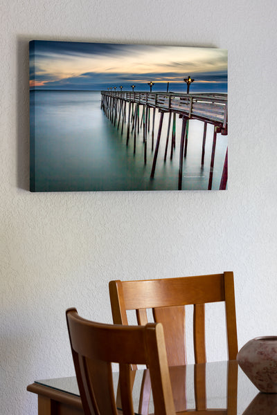 20"x30" x1.5" stretched canvas print hanging in the dining room of Long exposure of Kitty Hawk Pier at sunrise on the Outer Banks of NC.