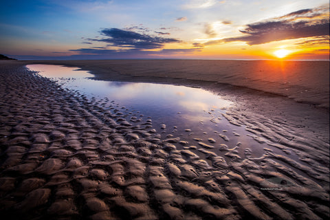 Sunrise reflection in a tide pool on a Corolla beach at Outer Banks, NC.