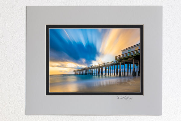 5 x 7 luster prints in a 8 x 10 ivory and black double mat of  Long exposure showing the motion of the clouds and surf at Kitty Hawk Fishing Pier sunrise on the Outer Banks of NC.
