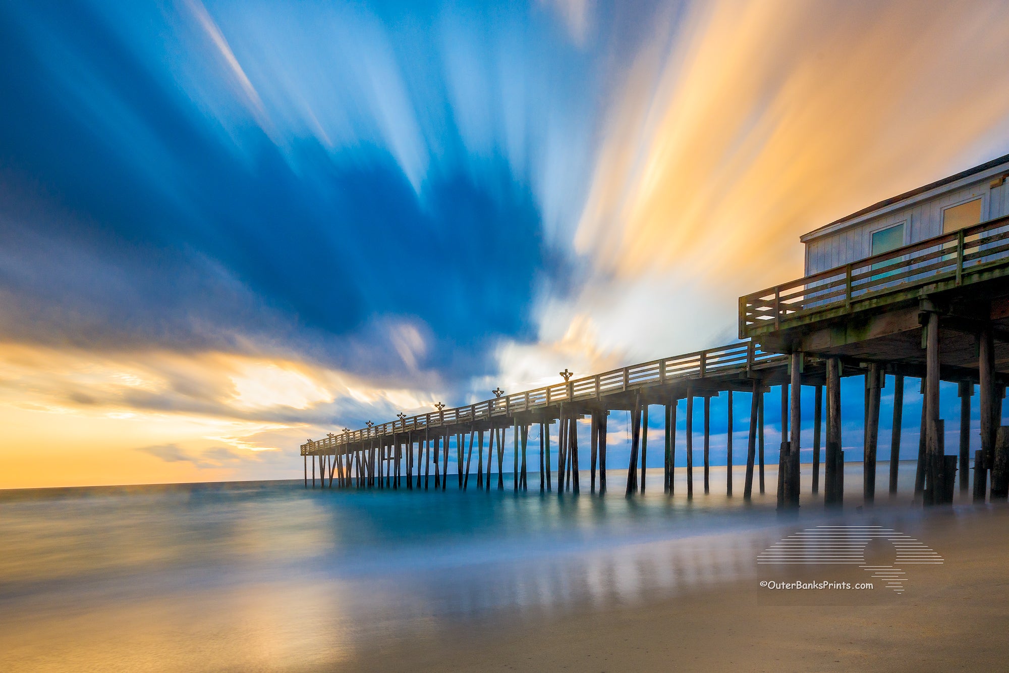 Long exposure showing the motion of the clouds and surf at Kitty Hawk Fishing Pier sunrise on the Outer Banks of NC.