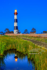 Bodie Island Lighthouse reflected in a small pond nestled into the marsh at twilight, on the Outer Banks of North Carolina.