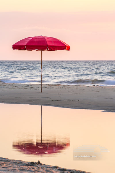Lonely umbrella reflected in a tide pool at a Duck, NC beach on the Outer Banks.