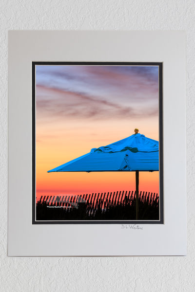 8 x 10 luster print in a 11 x 14 ivory and black double mat of Beach umbrella at sunrise on the Outer Banks.