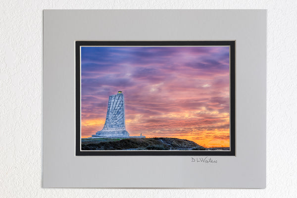 5 x 7 luster prints in a 8 x 10 ivory and black double mat of Sunrise cloudy sky create a backdrop behind the Wright Brothers Memorial in Kill Devil Hills North Carolina.
